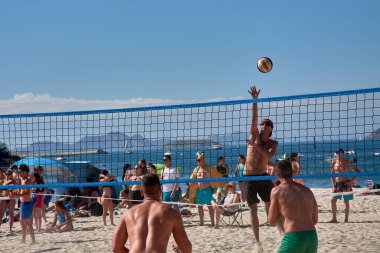 Sabaris, Baiona, Pontevedra, İspanya; 08,27,2024; Baiona 'da düzenlenen 3x3 Ladeira Plaj Voleybol Turnuvası sırasında, oyuncular bir hücum ve bir blok ile yoğun bir net mücadeleye giriştiler. Bu yüksek enerjili an atletizmi ve stratejiyi yakalıyor., 