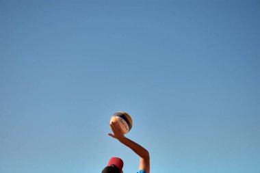 Sabaris, Baiona, Pontevedra, Spain; 08,27,2024;A low-angle shot captures the hands of beach volleyball players reaching for the ball, set against a clear blue sky during a match