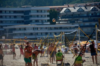 Sabaris, Baiona, Pontevedra, İspanya; 08,27,2024; Plaj voleybolcuları güneşli bir sahilde oynanan heyecan verici bir maçın ortasında yakalanır..