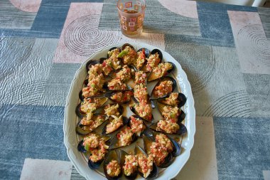 Close-up of a plate of freshly prepared mussels topped with a vibrant vinaigrette dressing. The dish is beautifully presented with chopped vegetables such as onions and red and green peppers, which add a burst of color and flavor.  clipart