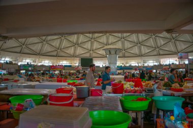 TASHKENT, UZBEKISTAN - 16 Eylül 2024: Taşkent, Özbekistan 'daki Chorsu Çarşısı' ndaki yuvarlak pavyon, tarım ticaretinin canlı bir merkezidir. Çarpıcı mavi kubbesiyle bilinen bu ikonik pazar, Tashkents ticari hayatının merkezi bir parçasıdır.. 