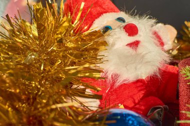 Güzel bir Noel süslemesinin yakın çekimi. Anlaşmada kırmızı böğürtlenlerle süslenmiş parlak kırmızı kurdele, çam kozalakları ve her zaman yeşil dallar yer alıyor.. 