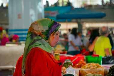 TASHKENT, UZBEKISTAN - 16 DE SEPTIEMBRE DE 2024: Taşkent, Özbekistan 'daki ünlü Chorsu Çarşısını ziyaret eden Arap kadınları. Geleneksel giysiler içinde, bu kadınlar yerel ürünler, baharatlar ve ürünlerle dolu, hareketli pazarı keşfediyorlar.. 