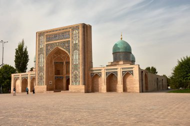 Taşkent, Özbekistan; Eylül, 16. 2024; Özbekistan 'ın Taşkent kentindeki önemli bir tarihi mekan olan görkemli Barak Khan Madrasah. Karmaşık fayanslar ve Kureyş yazıtlarıyla süslenmiş büyük merkezi kapı iki turkuaz kubbeli yapının arasında yer alır.