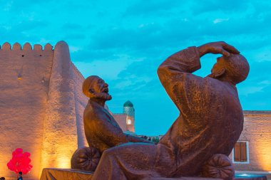 Özbekistan, Khiva 'nın bu nefes kesici gece manzarası tarihi İpek Yolu boyunca antik şehrin büyüsünü yakalar. Şehir mimarisi, gece gökyüzünün altında güzelce aydınlatılmış, yüksek minareleri, kubbeleri sergiliyor., 