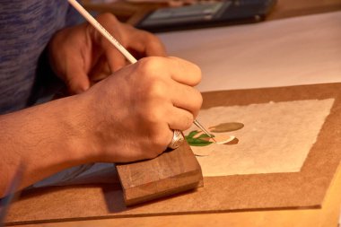 Bu büyüleyici görüntü, Özbekistan 'ın Buhara kentindeki canlı pazarlardan birinde bir zanaatkarın yetenekli ellerini gösteriyor..