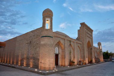 Özbekistan 'ın antik Khiva kentindeki ortaçağ binası. Karmaşık tuğla ve yumuşak gece aydınlatması yapının mimari güzelliğini ve tarihsel önemini vurguluyor.. 