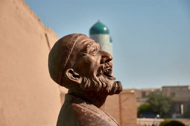 Özbekistan 'ın tarihi Khiva kentinde konuşan iki adamı resmeden bir heykelin karmaşık ayrıntılarını yakına çekiyoruz. Efsanevi İpek Yolu boyunca yer alan Khiva, uzun zamandır bir kültür ve ticaret kaynağıdır.. 