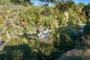 Hırvatistan 'ın Krka Ulusal Parkı' ndaki en ünlü şelalelerden biri olan Skradinski Buk Şelalesi. Şelale suları, antik bir su değirmeninin pitoresk manzarasıyla tamamlanır ve doğal güzelliğe tarihi bir cazibe katar.. 