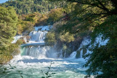Hırvatistan 'ın Krka Ulusal Parkı' ndaki en ünlü şelalelerden biri olan Skradinski Buk Şelalesi. Şelale suları, antik bir su değirmeninin pitoresk manzarasıyla tamamlanır ve doğal güzelliğe tarihi bir cazibe katar..