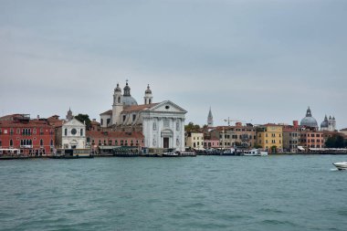 Venedik, İtalya; Ekim, 17. 2024: bulutlu bir günde Venedik 'in güzelliği, Santa Maria della Salute ve çevresindeki kanalları vurguluyor. Görkemli Barok Kilisesi kasvetli ve bulutlu gökyüzüne gururla karşı durmaktadır.