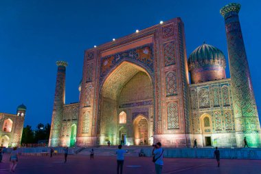 SAMARKAND, UZBEKISTAN - SEPTEMBER 17, 2024: Registan Square in Samarkand, Uzbekistan, illuminated under the evening sky. As a key location along the historic Silk Road, Registan Square is famous for its three grand madrasas clipart