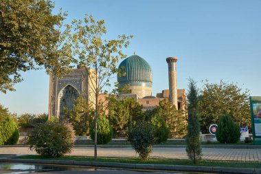 SAMARKAND, UZBEKISTAN - SEPTEMBER 17, 2024:Stunning blue dome and towering minaret of the Gur-e-Amir Mausoleum, the burial site of the conqueror Timur (Tamerlane), located in Samarkand, Uzbekistan.  clipart