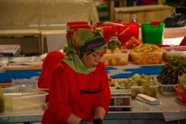 TASHKENT, UZBEKISTAN - 16 DE SEPTIEMBRE DE 2024: Taşkent, Özbekistan 'daki ünlü Chorsu Çarşısını ziyaret eden Arap kadınları. Geleneksel giysiler içinde, bu kadınlar yerel ürünler, baharatlar ve ürünlerle dolu, hareketli pazarı keşfediyorlar.. 