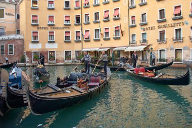 Venice,Italy;October,17,2024:On a sunny day in Venice, gondoliers expertly navigate the city's picturesque canals, showcasing a tradition that has been cherished for centuries. clipart