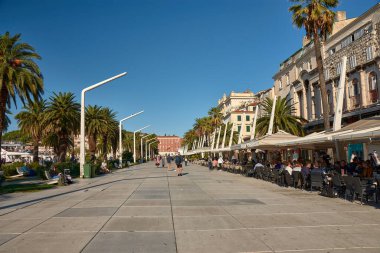 Hırvatistan 'ın Split kenti; Octubre (12.2024): Hırvatistan' ın Split kentinde bulunan Riva gezinti alanı, çok sayıda büyüleyici kafe, restoran ve barla dolu, hareketli bir liman sahası. Bu canlı konum Adriyatik Denizi 'nin çarpıcı manzaralarını sunuyor