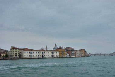 Venedik, İtalya; Ekim, 17. 2024: tipik Venedik mimarisi, canlı cepheler ve bir kanalın durgun sularına yansıyan terasotta çatıları. Renkli binalar, büyüleyici pencereleri ve balkonları