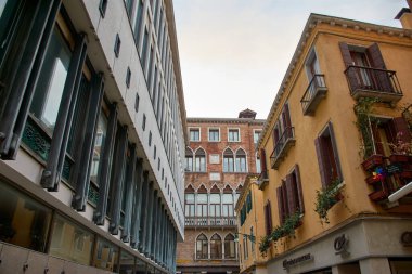 Venice,Italy;October,17,2024:In a quiet Venetian alley, soft, dim light filters through towering facades, casting delicate shadows and creating an enchanting atmosphere. clipart