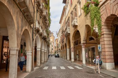 Treviso, Italia; 14 Ekim 2024: Calmaggiore, İtalya 'nın Treviso şehrinin tarihi cazibesi ve hareketli atmosferiyle bilinen ana ve ikonik sokaklarından biridir. Bu resim gibi cadde, zarif ortaçağ ve Rönesans binalarıyla dolu.