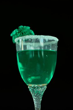 A stylish green liqueur served in a sugar-rimmed glass, enhanced with festive green decorations, and set against a deep black background. This image perfectly embodies the celebratory spirit of St. Patricks Day clipart