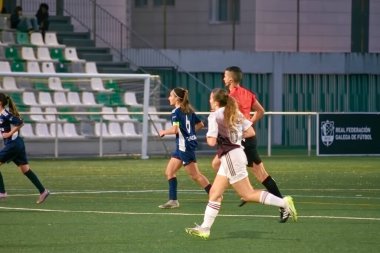 Vigo, Pontevedra, İspanya; 14 Aralık 2024: Galiçya 'nın Castilla-La Mancha ile karşı karşıya geldiği Vigo' da düzenlenen 16 yaş altı İspanyol Kadınlar Futbol Şampiyonası 'nda çekişmeli bir an. İki takım 0-0 biten yoğun ve hızlı bir oyuna giriyorlar. 