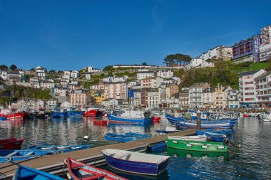 Luarca, Asturias, İspanya; 29 Mart 2025: İspanya 'nın Asturias kentindeki Luarca limanı, güneşli bir günde hem eğlence hem de balıkçı tekneleriyle dolu. Açık mavi sular renkli damarları yansıtıyor ve canlı bir manzara yaratıyor. Resim Vurgulaması