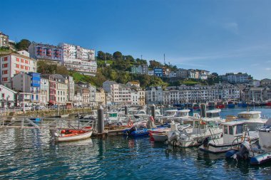 Luarca, Asturias, İspanya; 29 Mart 2025: İspanya 'nın Asturias kentindeki Luarca limanı, güneşli bir günde hem eğlence hem de balıkçı tekneleriyle dolu. Açık mavi sular renkli damarları yansıtıyor ve canlı bir manzara yaratıyor. Resim Vurgulaması