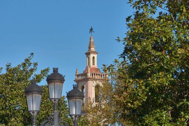 İspanya, Asturias, Vegadeo 'daki Nuestra Senora de La Asuncion Kilisesi' nin çan kulesi güneşli bir gökyüzünün altında. Kulenin detaylı mimarisi ve tarihi önemi vurgulandı. 