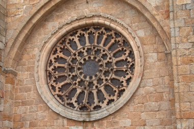 Bu yakın plan görüntü, İspanya 'nın Lugo kentindeki Mondoedo Katedrali' nin ön cephesindeki gül penceresinin karmaşık güzelliğini yakalar. Detaylı çekim pencerenin ayrıntılı tasarımı ve mimari önemini vurguluyor. 