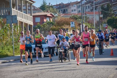 Nigran, Pontevedra, İspanya; 6 Nisan 2025; Bu yakın plan, İspanya 'nın Nigran kentinden geçerken yıllık Vigo-Bayona maratonuna katılan koşucuların enerjilerini ve kararlılıklarını yakalar. Fotoğraf yarışın şiddetini vurguluyor ve...