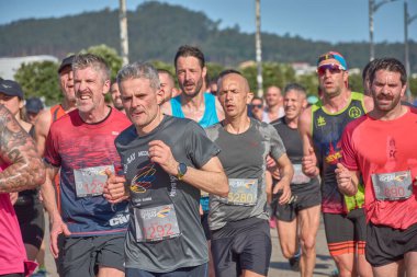 Nigran, Pontevedra, İspanya; 6 Nisan 2025; Bu yakın plan, İspanya 'nın Nigran kentinden geçerken yıllık Vigo-Bayona maratonuna katılan koşucuların enerjilerini ve kararlılıklarını yakalar. Fotoğraf yarışın şiddetini vurguluyor ve...