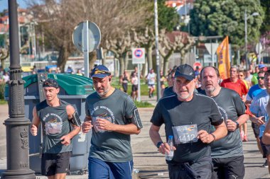 Nigran, Pontevedra, İspanya; 6 Nisan 2025; Bu yakın plan, İspanya 'nın Nigran kentinden geçerken yıllık Vigo-Bayona maratonuna katılan koşucuların enerjilerini ve kararlılıklarını yakalar. Fotoğraf yarışın şiddetini vurguluyor ve...