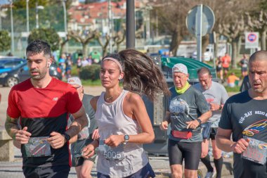 Nigran, Pontevedra, İspanya; 6 Nisan 2025; Bu yakın plan, İspanya 'nın Nigran kentinden geçerken yıllık Vigo-Bayona maratonuna katılan koşucuların enerjilerini ve kararlılıklarını yakalar. Fotoğraf yarışın şiddetini vurguluyor ve...