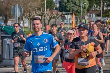 Nigran, Pontevedra, İspanya; 6 Nisan 2025; Bu yakın plan, İspanya 'nın Nigran kentinden geçerken yıllık Vigo-Bayona maratonuna katılan koşucuların enerjilerini ve kararlılıklarını yakalar. Fotoğraf yarışın şiddetini vurguluyor ve...