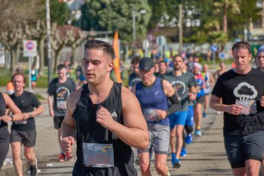 Nigran, Pontevedra, İspanya; 6 Nisan 2025; Bu yakın plan, İspanya 'nın Nigran kentinden geçerken yıllık Vigo-Bayona maratonuna katılan koşucuların enerjilerini ve kararlılıklarını yakalar. Fotoğraf yarışın şiddetini vurguluyor ve...