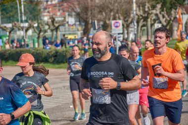 Nigran, Pontevedra, İspanya; 6 Nisan 2025; Bu yakın plan, İspanya 'nın Nigran kentinden geçerken yıllık Vigo-Bayona maratonuna katılan koşucuların enerjilerini ve kararlılıklarını yakalar. Fotoğraf yarışın şiddetini vurguluyor ve...