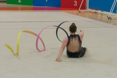 Vigo, Pontevedra, İspanya; 12 Nisan 2025; yetenekli bir jimnastikçi modern Vigo Belediye Spor Salonu 'nda zarif bir şekilde ritmik jimnastik kurdele egzersizleri yapar. Akışkan hareketleri ve kusursuz kontrolü bu disiplinin güzelliğini vurguluyor..