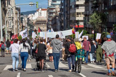 Vigo, Pontevedra, İspanya, 1 Mayıs 2025 'te İspanya' nın Vigo kentinde düzenlenen 1 Mayıs Uluslararası İşçi Bayramı gösterisine büyük bir grup insan katıldı. Kalabalık caddelerde yürürken renkli bayraklar ve afişler görülüyor.