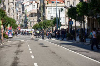 Vigo, Pontevedra, İspanya, 1 Mayıs 2025 'te İspanya' nın Vigo kentinde düzenlenen 1 Mayıs Uluslararası İşçi Bayramı gösterisine büyük bir grup insan katıldı. Kalabalık caddelerde yürürken renkli bayraklar ve afişler görülüyor.