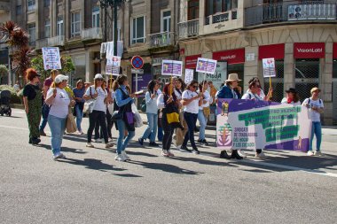 Vigo, Pontevedra, İspanya, 1 Mayıs 2025 'te İspanya' nın Vigo kentinde düzenlenen 1 Mayıs Uluslararası İşçi Bayramı gösterisine büyük bir grup insan katıldı. Kalabalık caddelerde yürürken renkli bayraklar ve afişler görülüyor.