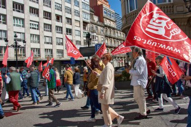 Vigo, Pontevedra, İspanya, 1 Mayıs 2025 'te İspanya' nın Vigo kentinde düzenlenen 1 Mayıs Uluslararası İşçi Bayramı gösterisine büyük bir grup insan katıldı. Kalabalık caddelerde yürürken renkli bayraklar ve afişler görülüyor.