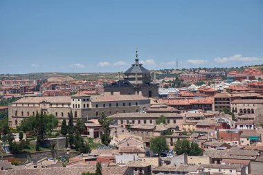 Görkemli Tavera Hastanesi, İspanyol Rönesans mimarisinin bir başyapıtı, simetrik cephesi ve Toledo güneşinin altında parlayan karmaşık taş işidir.. 