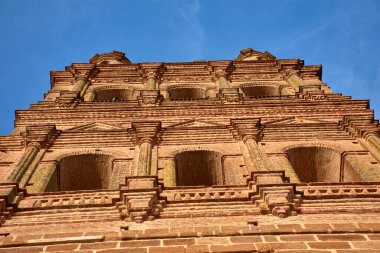 Badajoz, Llerena 'daki Granada Kilisesi' nin yukarı bakan manzarasında Mudejar mimarisi ve açık gökyüzü ile kırmızı taş kontrastının sıcaklığı