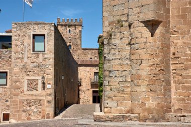 Görüntüler Caceres 'in eski kasabasının sokak mimarisinin özünü yakalıyor, heybetli taş kuleleri ve canlı mavi gökyüzünün altında yükselen tarihi cepheleri gösteriyor.. 