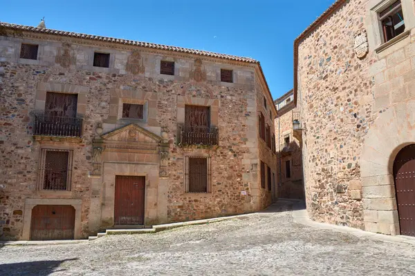 Görüntüler Caceres 'in eski kasabasının sokak mimarisinin özünü yakalıyor, heybetli taş kuleleri ve canlı mavi gökyüzünün altında yükselen tarihi cepheleri gösteriyor.. 