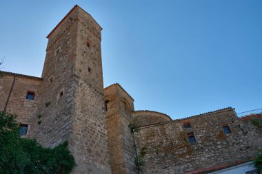 Yaşlı Luis de Chaves Kalesi 'nin etkileyici alçak açılı manzarası. Trujillo, Extremadura' da bulunan bir ortaçağ savunma yapısı. Kompozisyon, tamamen mavi gökyüzünün altındaki taş kulenin dikeyliğini vurguluyor.