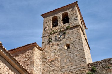 Santa Maria de Aguas Vivas Kilisesi 'nin sağlam çan kulesi Hervas' ta ihtişamlı bir şekilde duruyor. Eski detaylarıyla taş yapısını gözler önüne seriyor. Ön cephesinde bir saat.. 