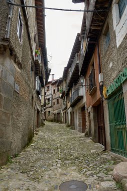 Alberca, Salamanca, İspanya, 19 Mayıs 2025, La Alberca, Salamanca 'da dar bir sokakta yarı ahşap ve taş cepheli geleneksel mimari.