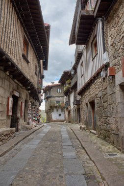 Alberca, Salamanca, İspanya, 19 Mayıs 2025, La Alberca, Salamanca 'da dar bir sokakta yarı ahşap ve taş cepheli geleneksel mimari.