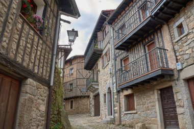 Alberca, Salamanca, İspanya, 19 Mayıs 2025, La Alberca, Salamanca 'da dar bir sokakta yarı ahşap ve taş cepheli geleneksel mimari.